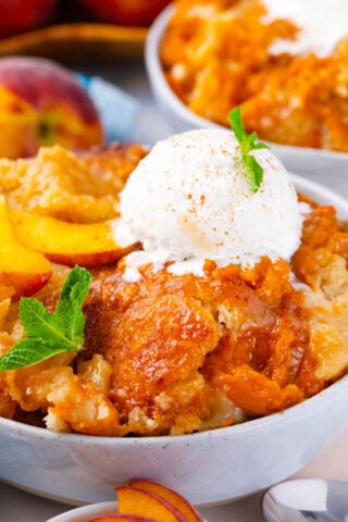 Homemade peach cobbler topped with ice cream.