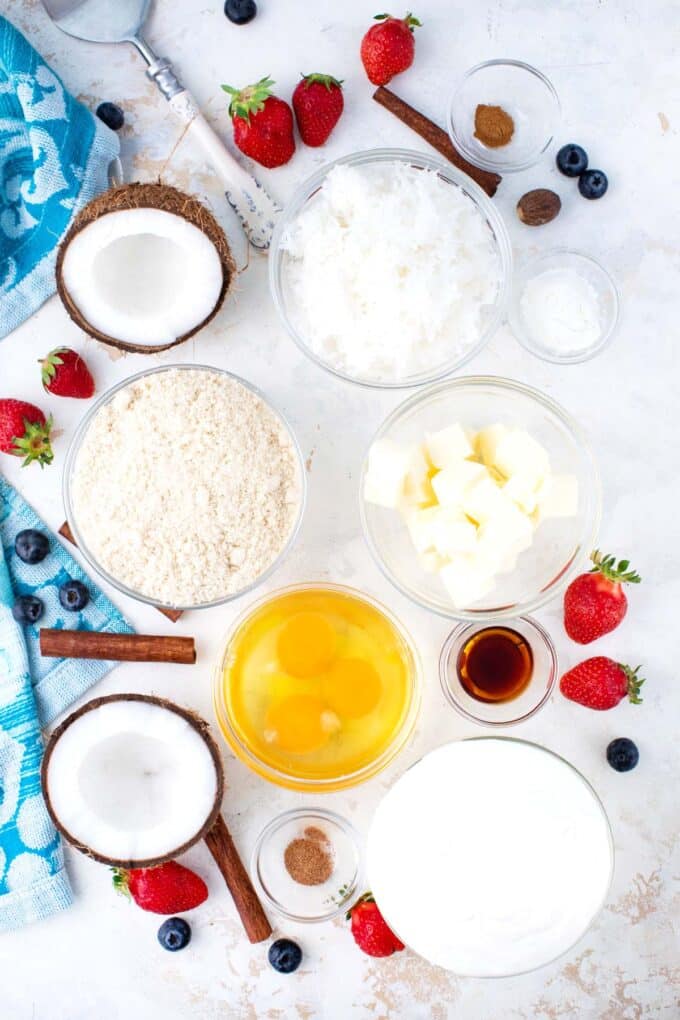 Overhead shot of keto cheesecake ingredients in bowls on a table.