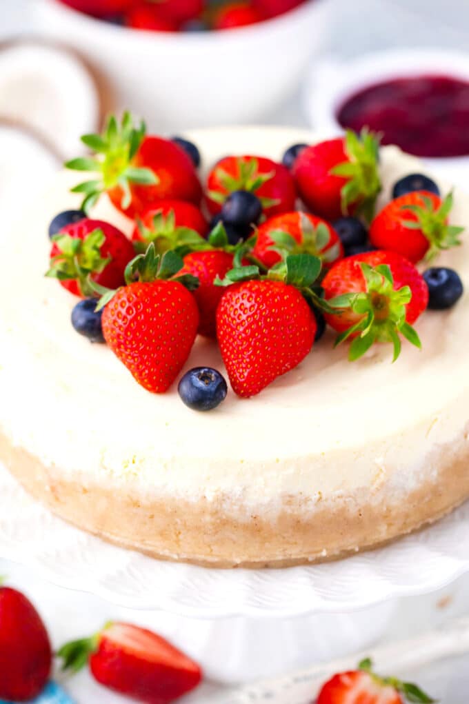 Homemade keto cheesecake topped with fresh strawberries and blueberries.