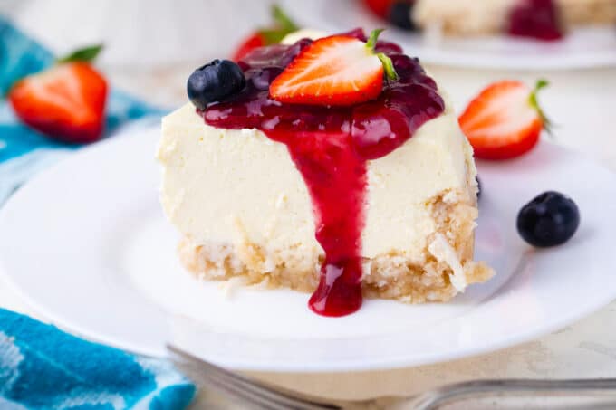 A slice of keto cheesecake topped with berry sauce.