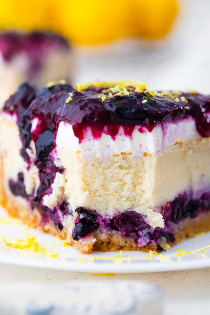 Close shot of blueberry french custard cake with lemon frosting, blueberry sauce and lemon zest.