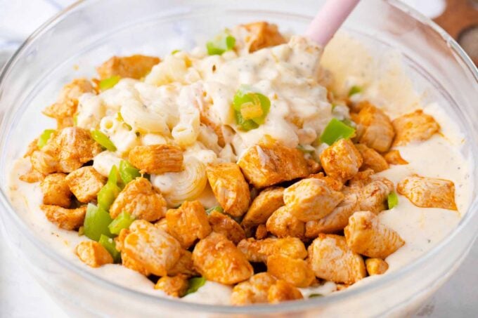 Mixing the ingredients for cheesy crack chicken casserole in a bowl.