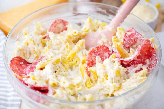 Mixing white pizza casserole ingredients in a bowl.