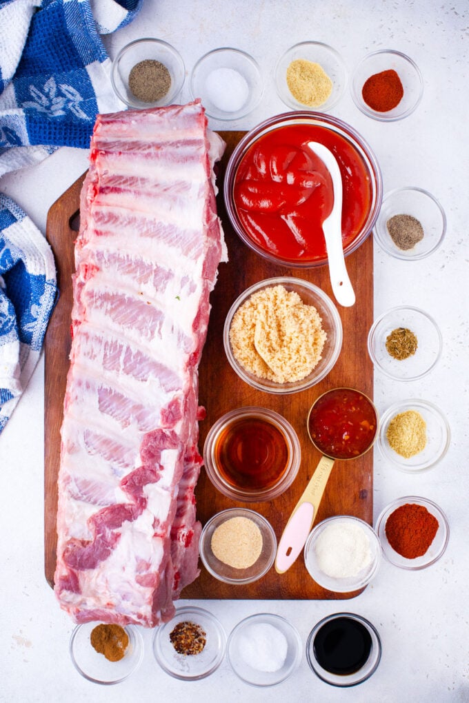 Overhead shot of oven baked barbecue ribs ingredients arranged on a table.