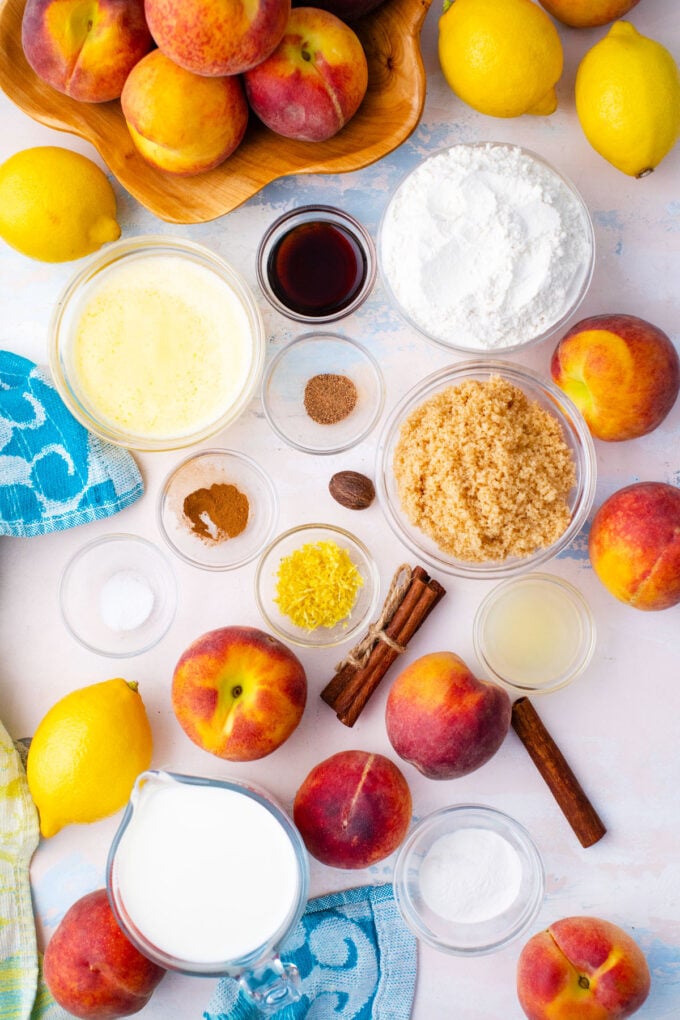 Overhead shot of peach cobbler ingredients in bowls on a table.
