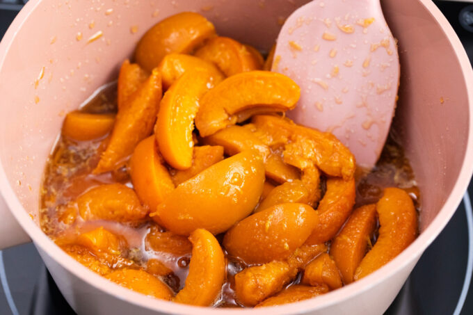 Stirringpeach filling in a saucepan.
