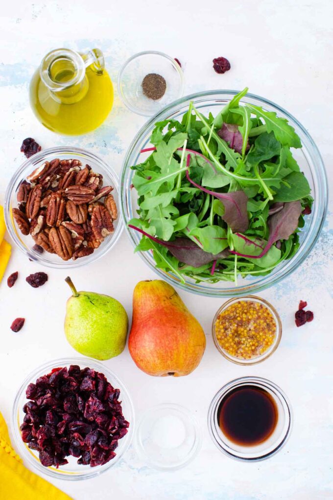 pear salad ingredients in bowls on a light surface