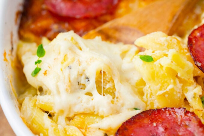 Close shot of cheesy pasta in white pizza casserole.