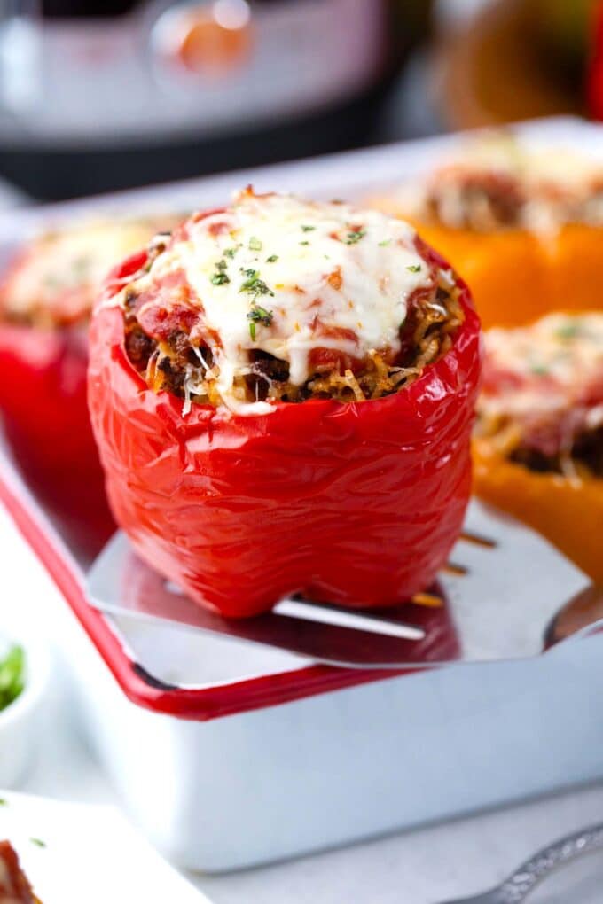 instant pot stuffed peppers topped with marinara sauce and cheese in a baking dish