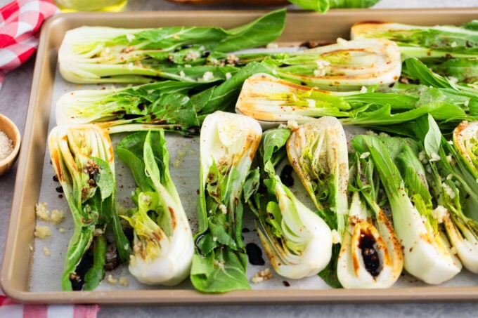 Bok choy with garlic on a roasting sheet.