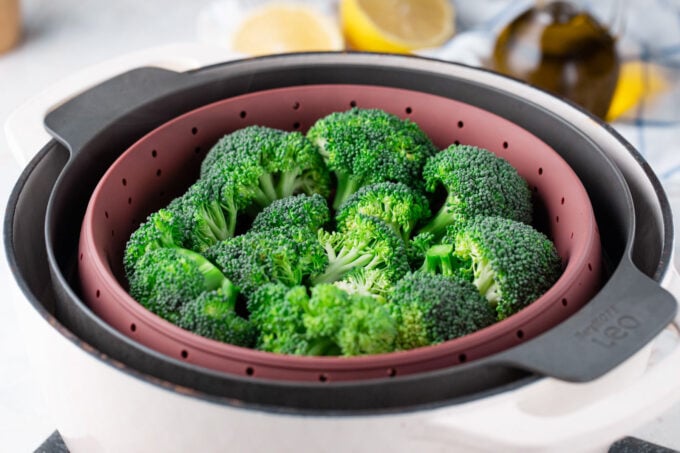 Broccoli florets in a steamer basket.