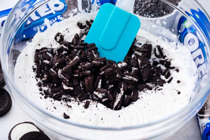 Folding crushed Oreos into mousse mixture.