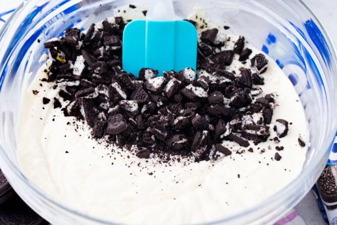 Folding crushed Oreos into cheesecake batter.