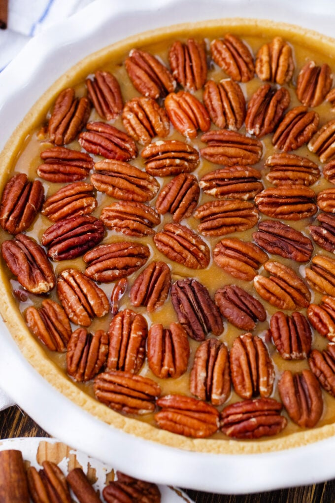 Baking pecan pie topped with pecans.