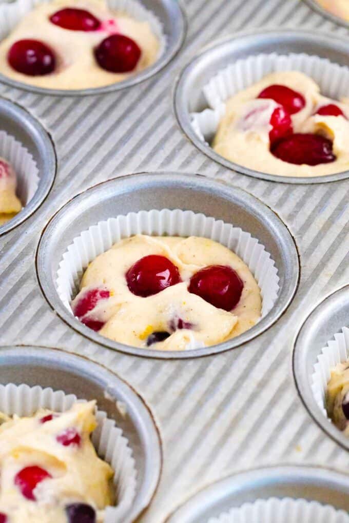 cranberry orange muffin batter in a muffin pan