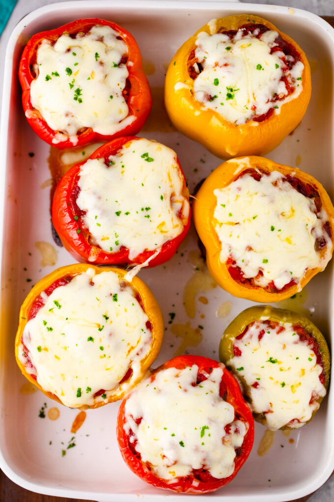 Overhead shot of cheesy stuffed peppers in a baking dish.