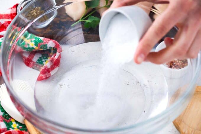 Adding salt to a bowl of water to make a brine.