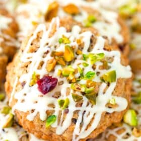 cranberry pistachio oatmeal cookies with white chocolate drizzle and chopped pistachios