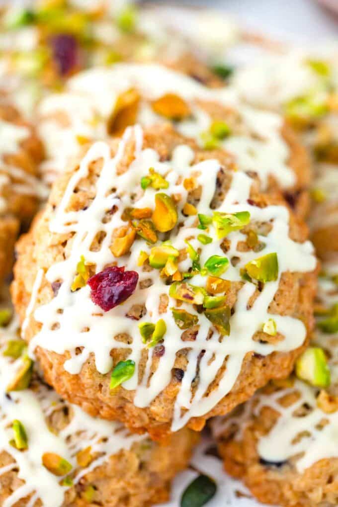 cranberry pistachio oatmeal cookies with white chocolate drizzle and chopped pistachios