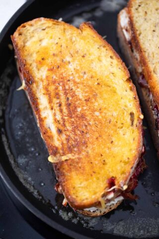 cooking a crispy grilled cheese sandwich in butter in a skillet