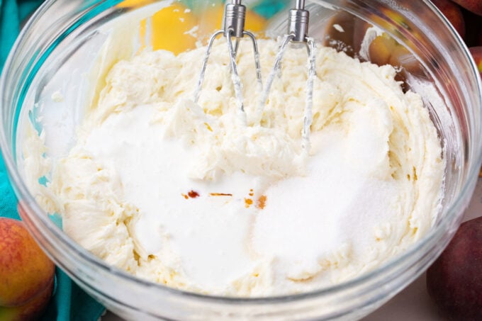 Whisking cream cheese and sugar in a bowl.