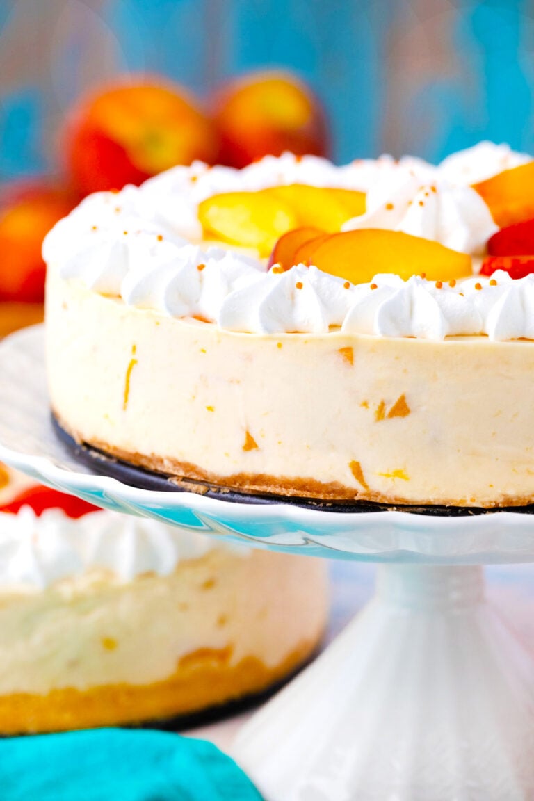 No bake peach cheesecake on a cake stamnd.