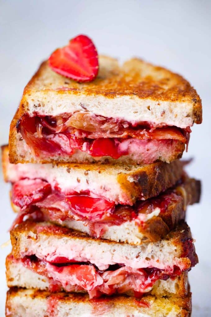 crispy strawberry bacon grilled cheese sandwich cut in half and stacked on top of each other