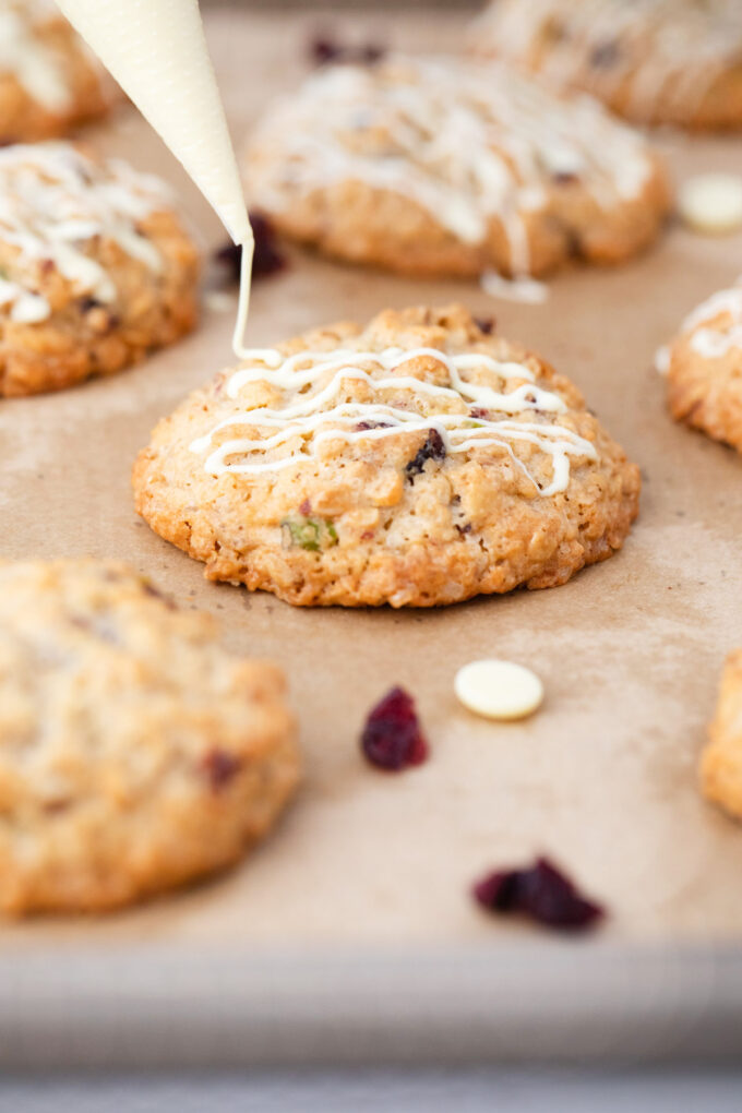 Drizzling white chocolate over cranberry pistachio cookie.