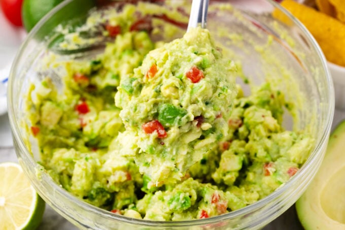 A serving spoon of chunky guacamole.