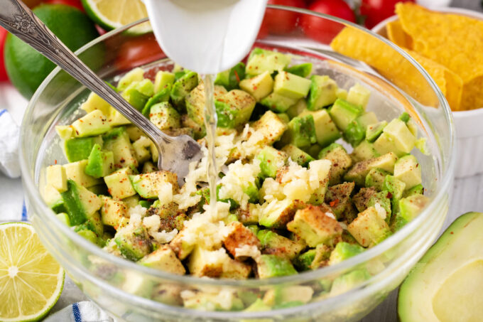 Mixing guacamole ingredients into a bowl.