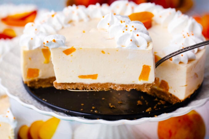 A slice of no bake peach cheesecake on a serving spatula.
