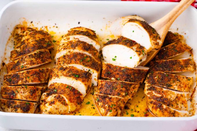Sliced, oven baked chicken breast, in a baking dish.