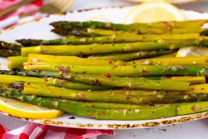 Oven roasted asparagus spears on a serving plate.