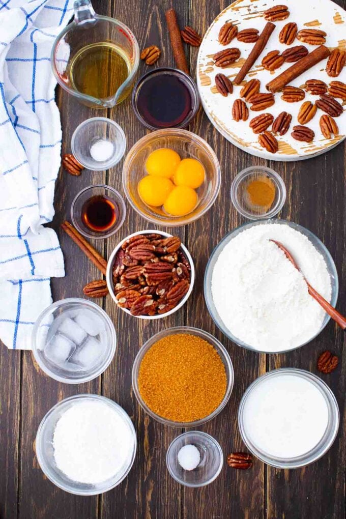 pecan pie ingredients arranged in bowls on a wooden surface