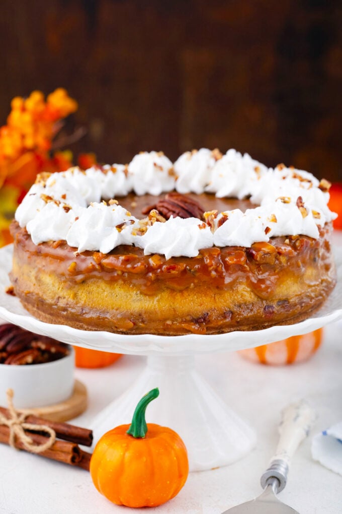 Pecan pie pumpkin cheesecake on a cake stand.