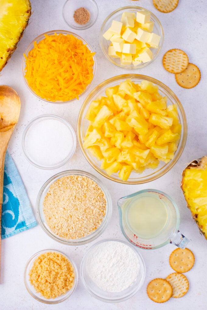 Overhead shot of pineapple casserole ingredients in bowls on a table.