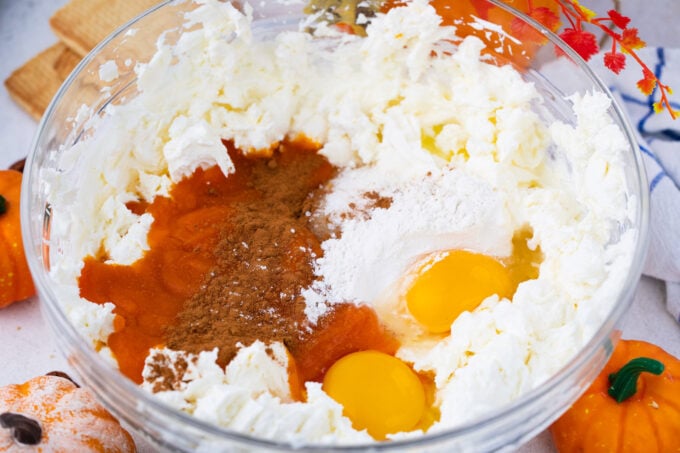 Pumpkin cheesecake ingredients in a bowl.