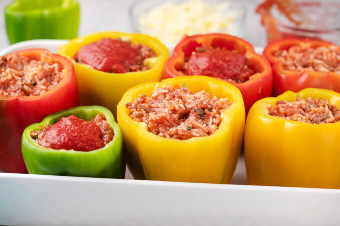 Stuffing bell peppers with beef and rice mixture.