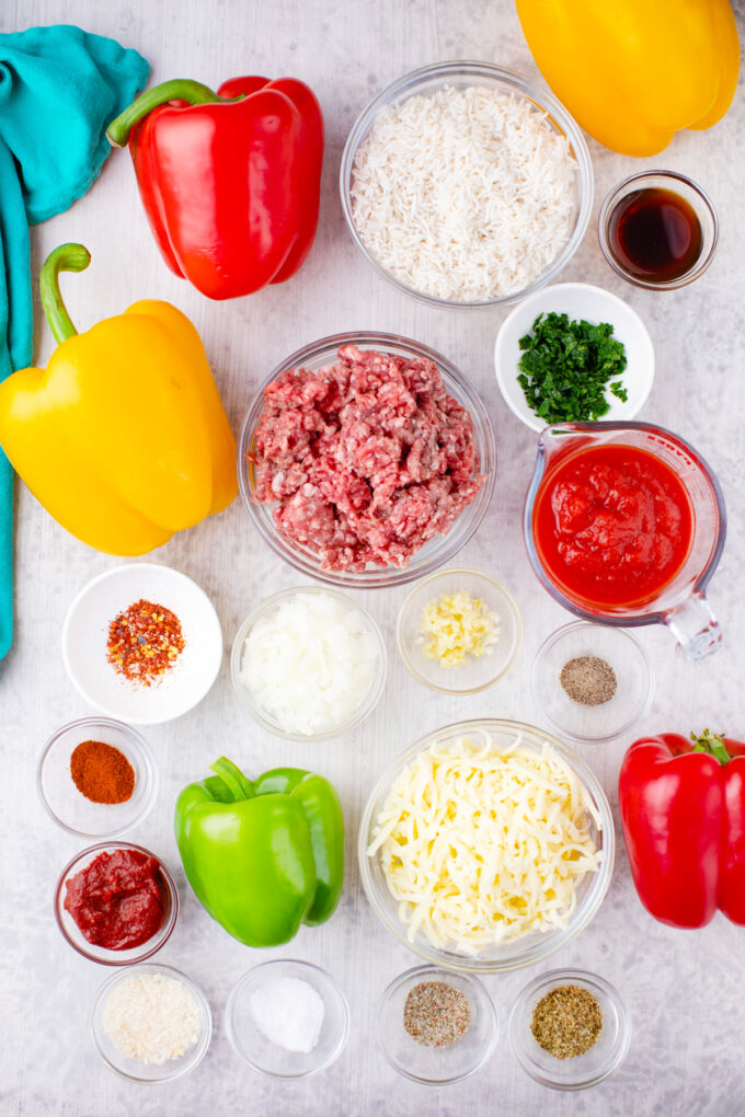 Overhead shot of stuffed peppers ingredients arranged on a white table.