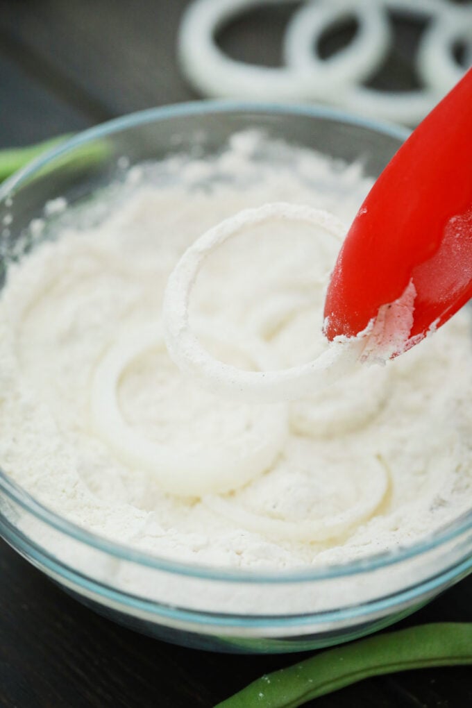 Tossing onion rings in flour mixture.