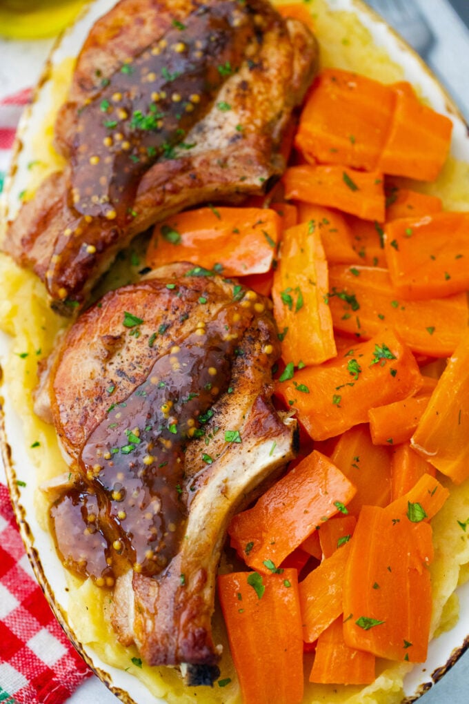 Homemade Instant Pot apple cider pork chops with carrot chunks and mashed potatoes.