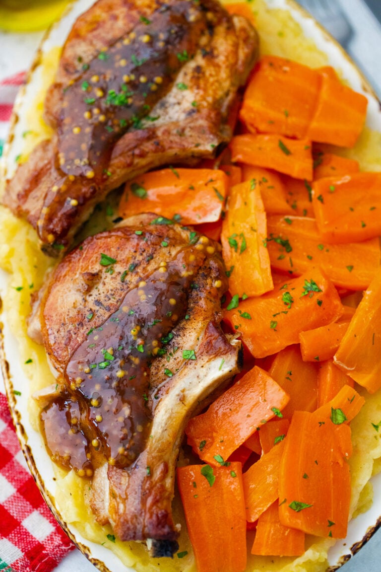 Homemade Instant Pot apple cider pork chops with carrot chunks and mashed potatoes.