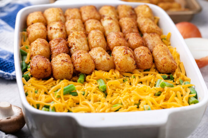 Layering homemade tater tot casserole.