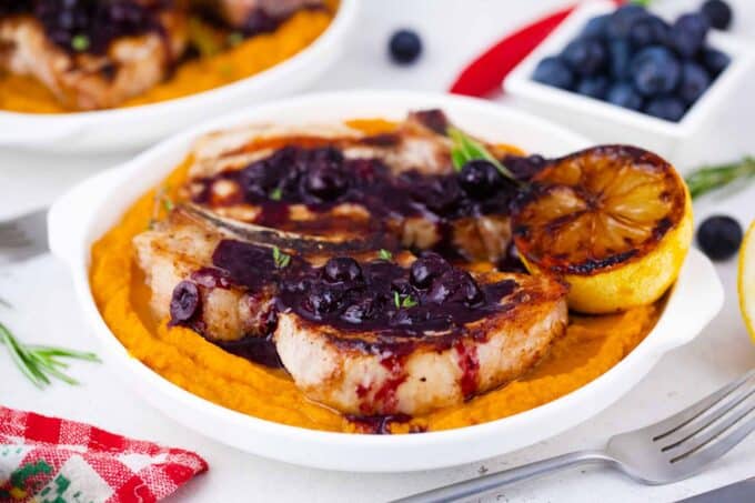 bone in blueberry pork chops topped with blueberry sauce and served over mashed sweet potatoes