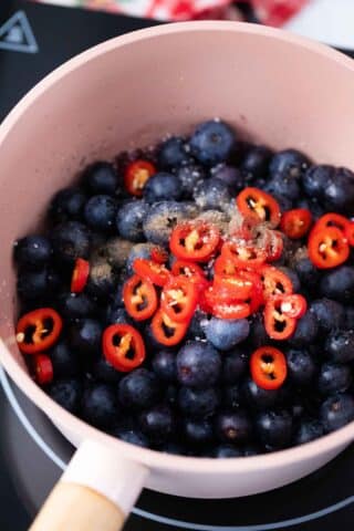 blueberries and chili pepper in a saucepan