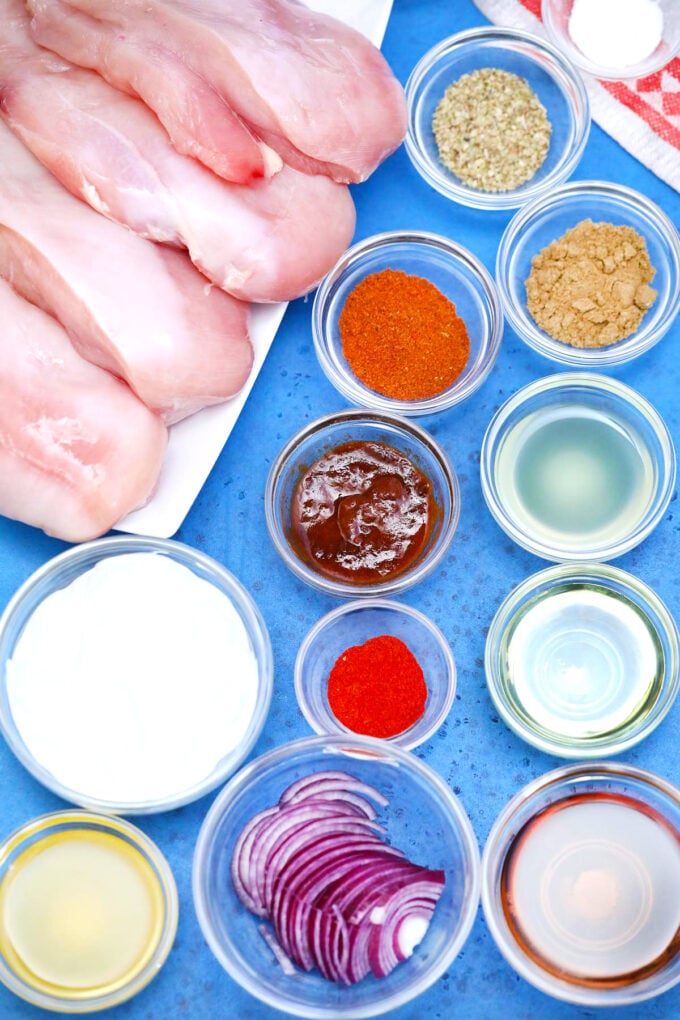 Chipotle chicken tacos ingredients in bowls on a blue table.