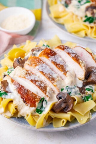 Overhead shot of creamy parmesan mushroom chicken over egg noodles.
