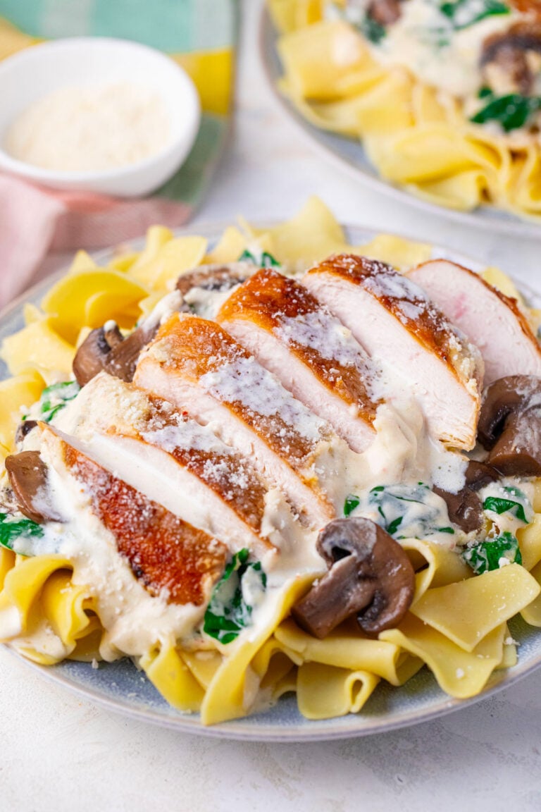Overhead shot of creamy parmesan mushroom chicken over egg noodles.