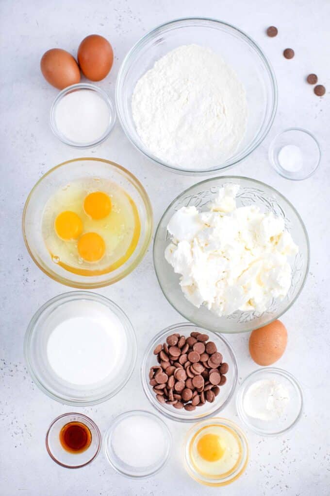 crepe stuffed new york cheesecake ingredients in bowls on a white surface