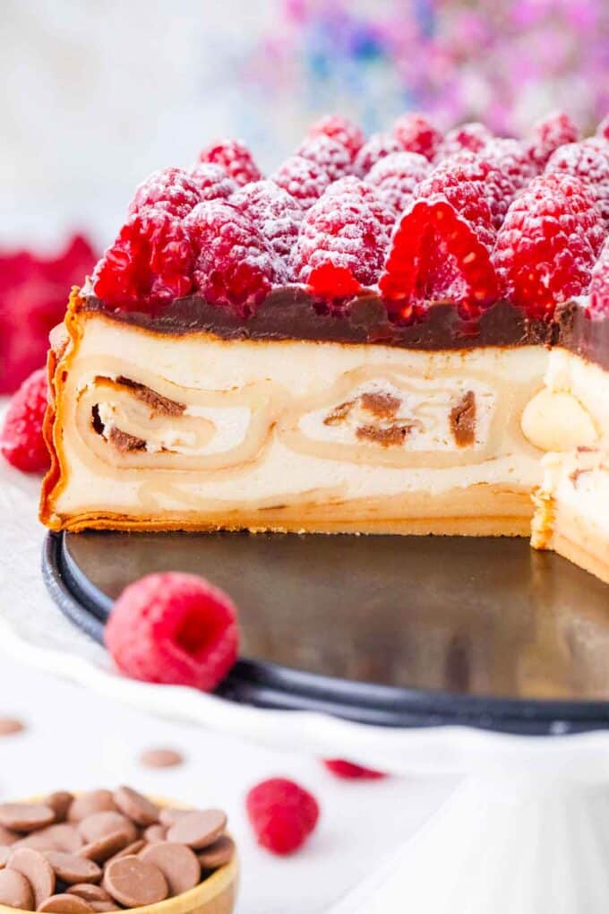 sliced crepe stuffed new york cheesecake with chocolate ganache and raspberries